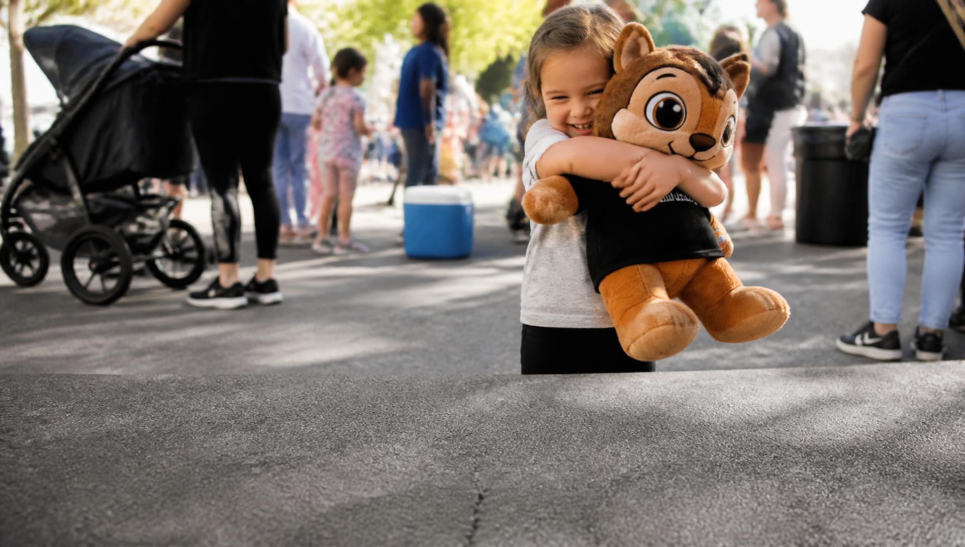 Kind omhelst een pluche mascotte tijdens een evenement