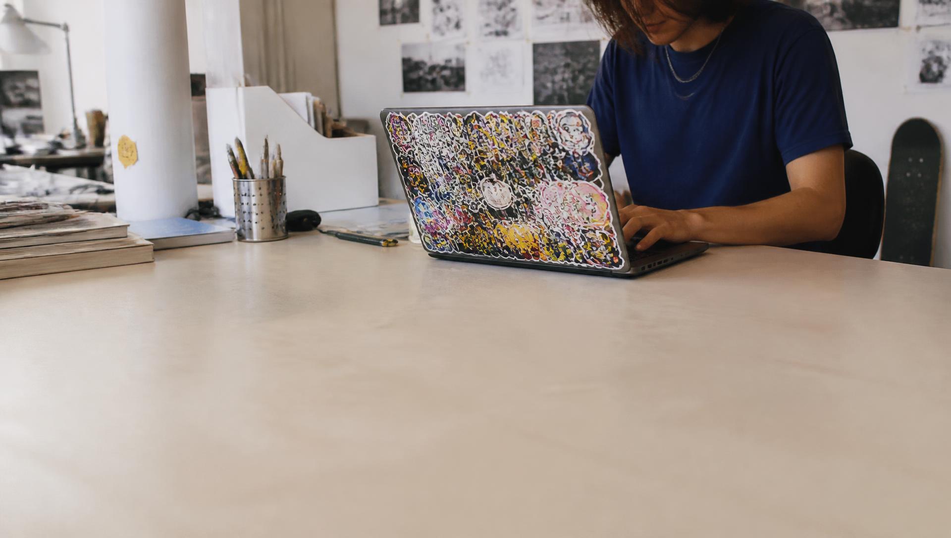 Beplakte laptop met stickers in een creatieve studentenomgeving