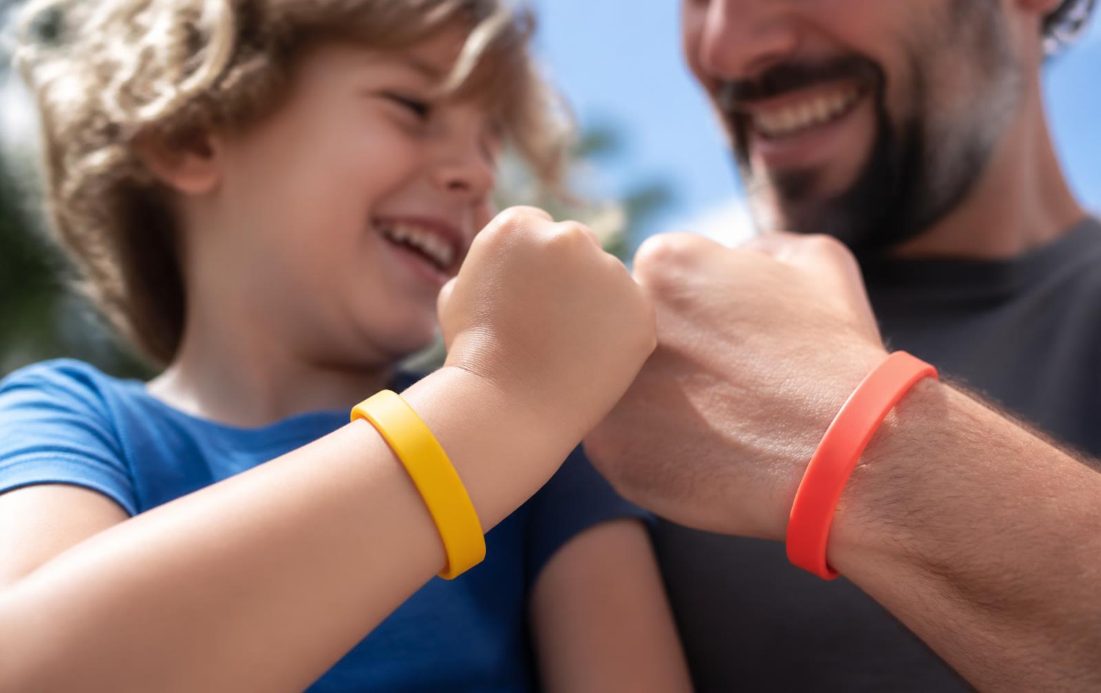 Kind en volwassene met siliconen armbandjes in de zon